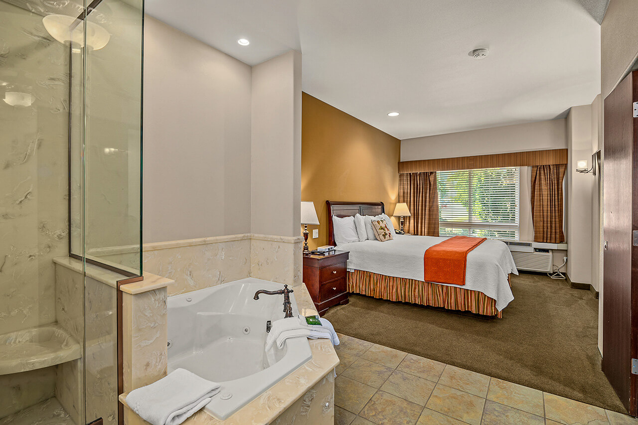 a photo of the Redwood Hyperion Suites guest room showing a large jetted tub and comfortable master suite