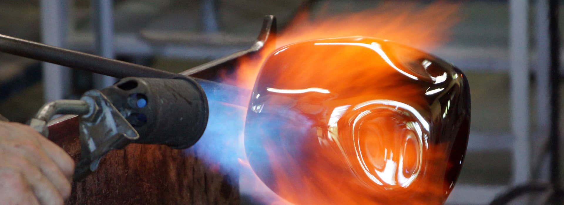 a photo of an artisan blowing glass