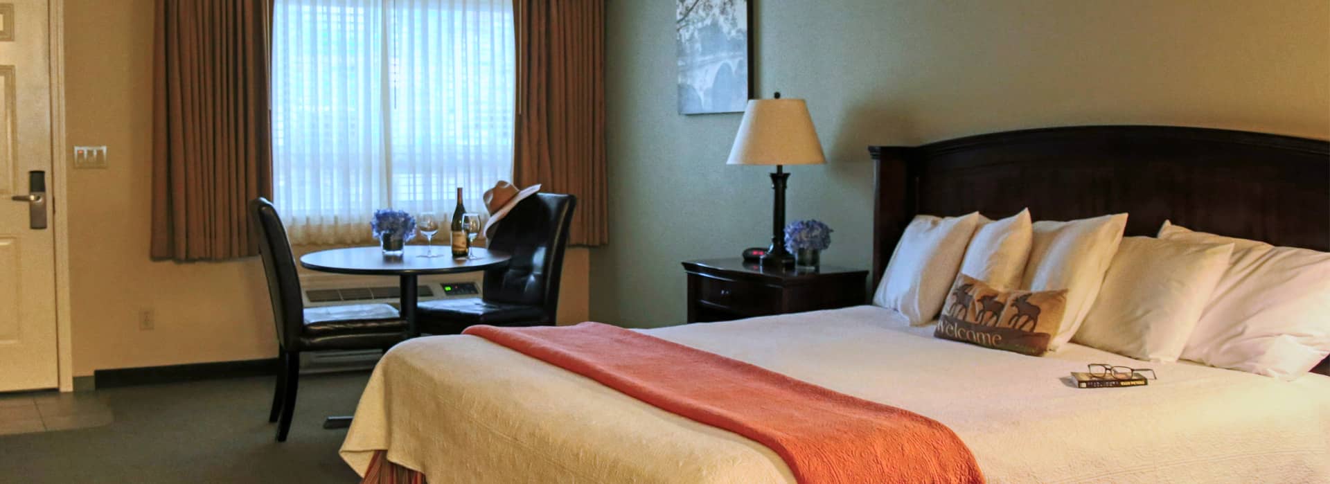 A photo of a room with a king size bed at the Redwood Hyperion Suites in Grants pass, OR